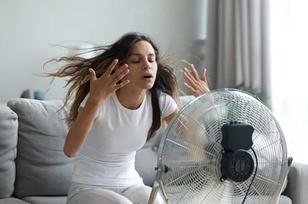 Girl cooling off with fan